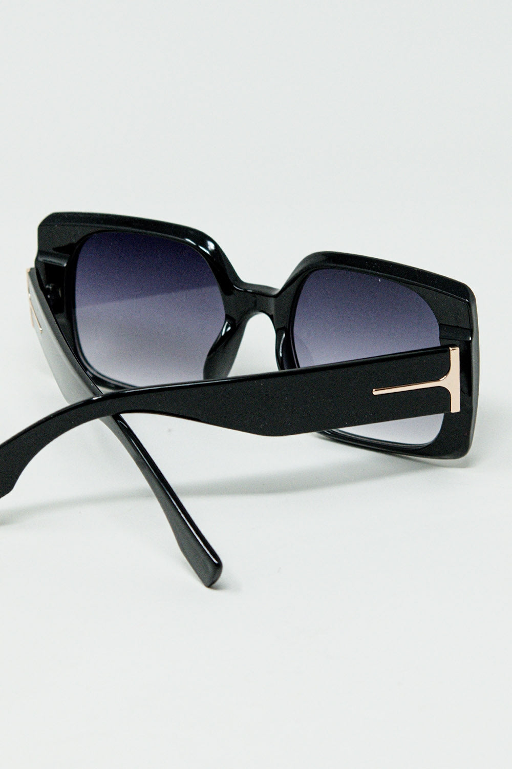 Gafas de sol cuadradas negras con detalle dorado en el lateral Q2