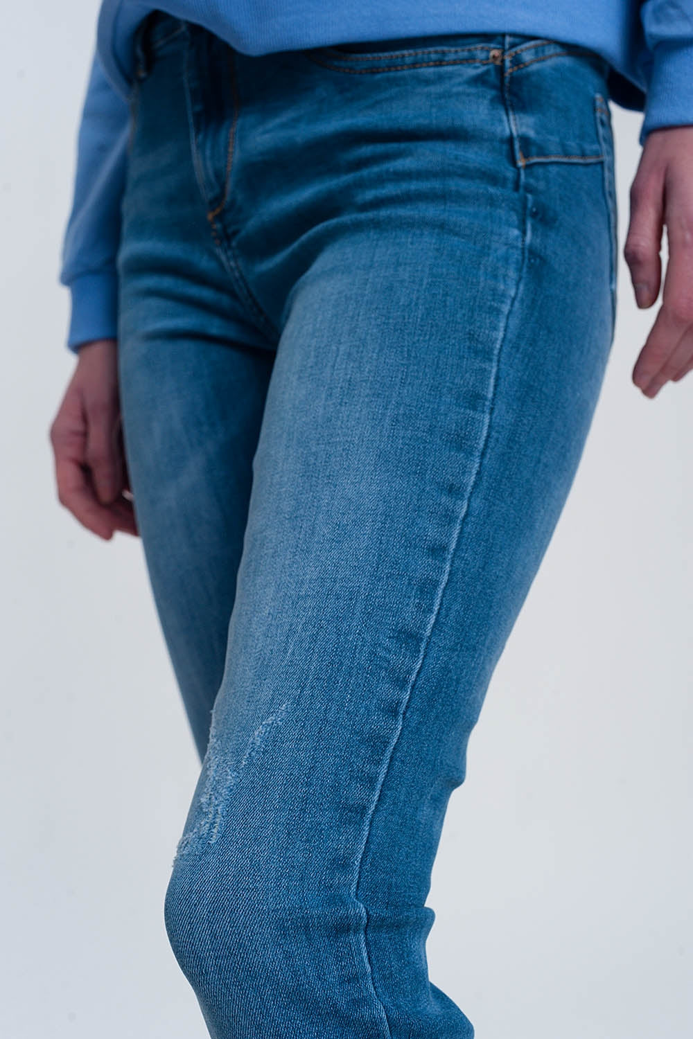 jeans ajustados de mezclilla clara con tobillos doblados y detalle rasgado Q2