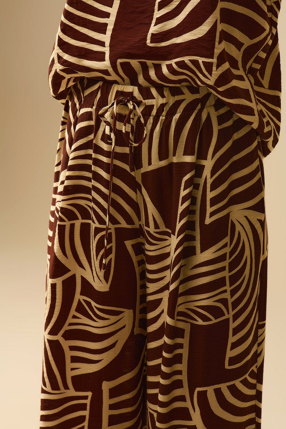 Pantalón marrón de pernera ancha con estampado de hojas blancas Q2