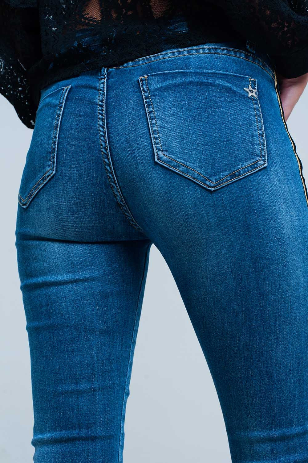 Pantalon vaquero azul con banda lateral dorada y negra Q2