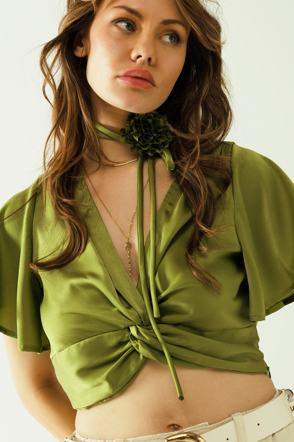 Top verde con cuello en V manga corta y detalle floral en el cuello Q2