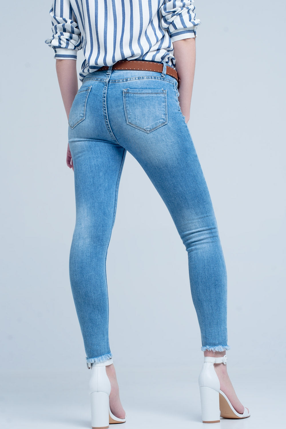 Vaqueros ajustados en azul con detalle rasgado Q2