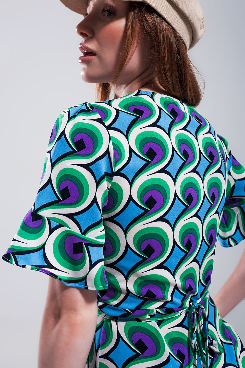 Vestido corto azul cruzado con volantes en el bajo y estampado estilo años 70 Q2