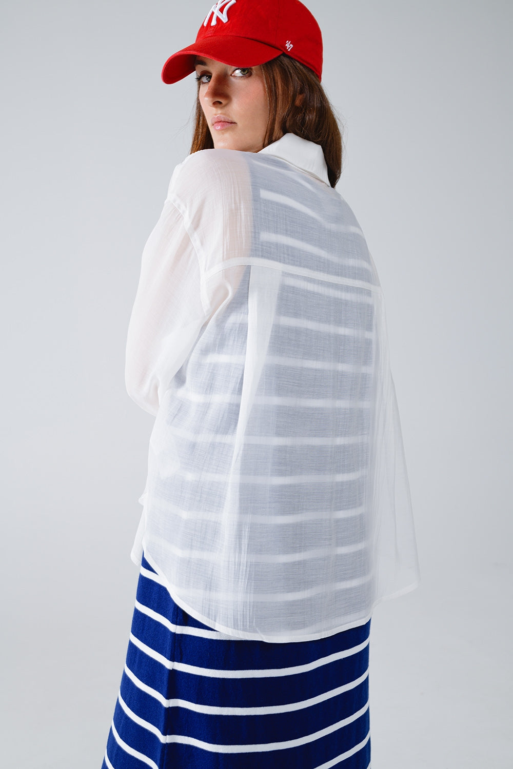 Blusa blanca semitransparente con detalle de volante en la parte delantera Q2