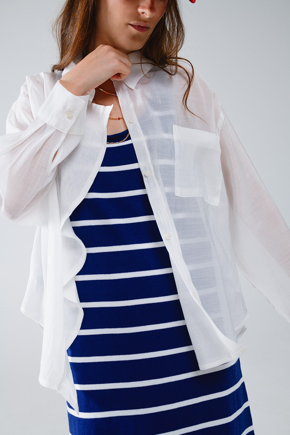 Blusa blanca semitransparente con detalle de volante en la parte delantera Q2