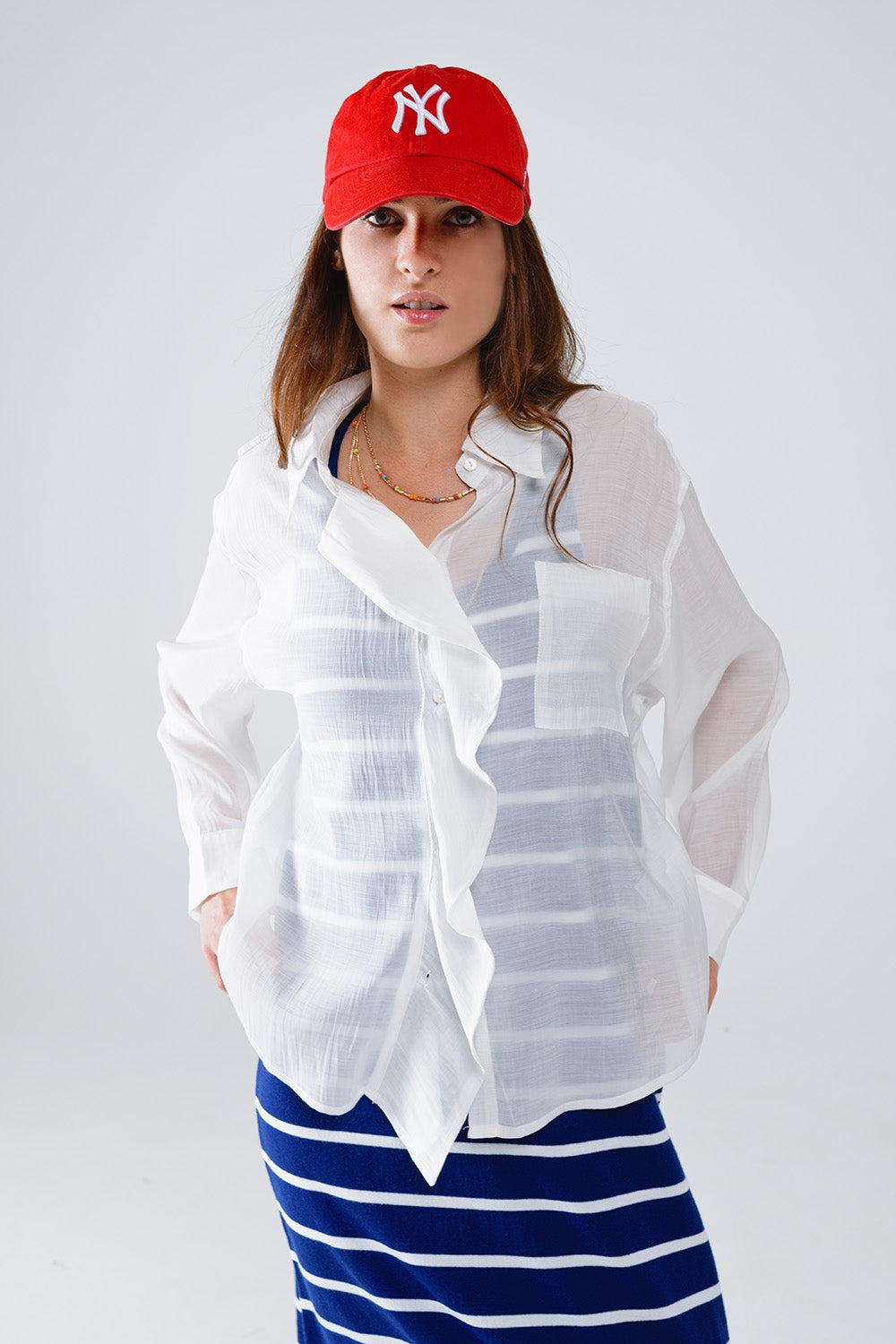 Blusa blanca semitransparente con detalle de volante en la parte delantera Q2