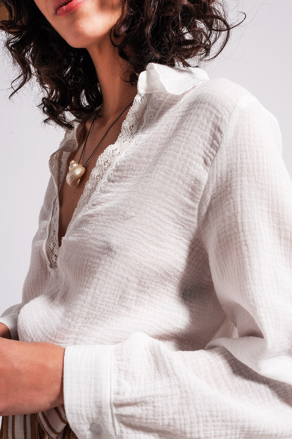 Blusa color crema con cuello de pico y detalle de encaje Q2