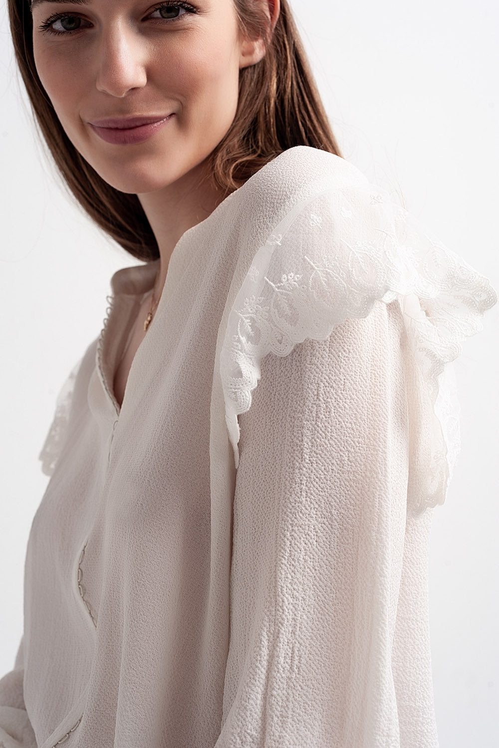 Blusa con volumen en las mangas y volantes en los puños en color crema Q2