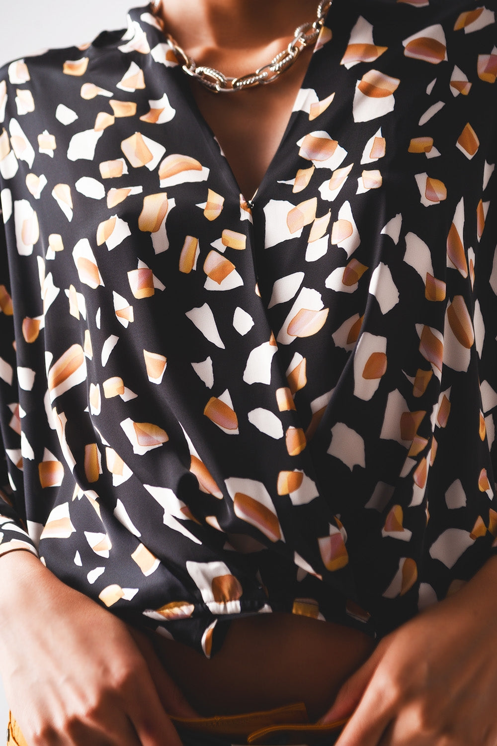 Blusa negra con estampado y parte delantera cruzada Q2