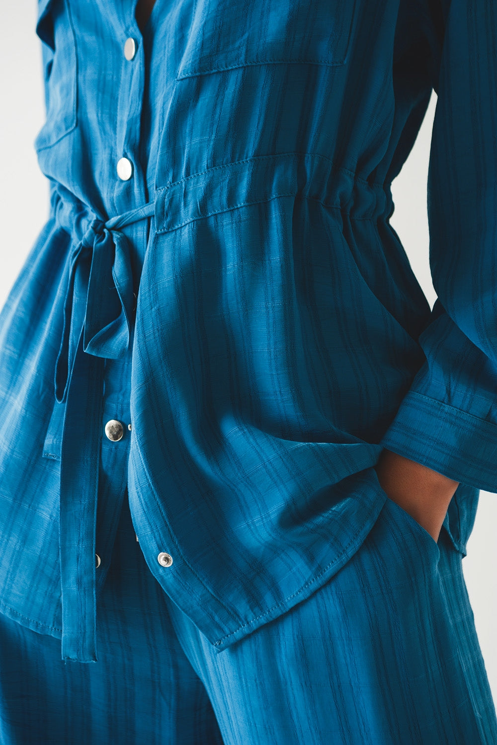 Camisa azul de manga larga con lazada en la cintura Q2