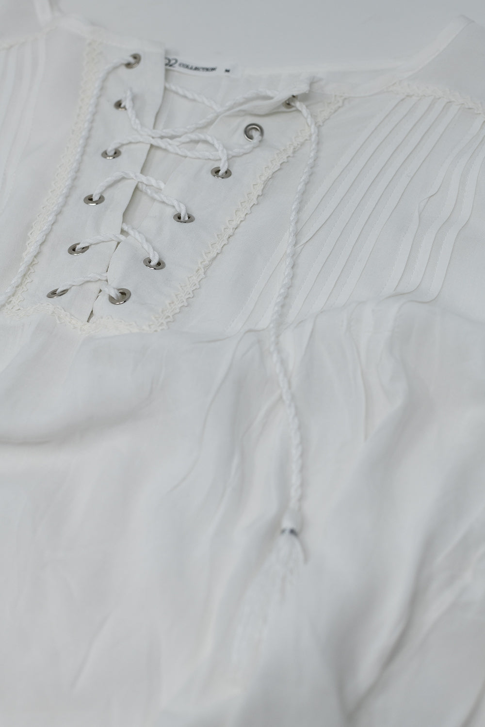 Camisa blanca con extremos de borla y cierre de lazo cruzado Q2