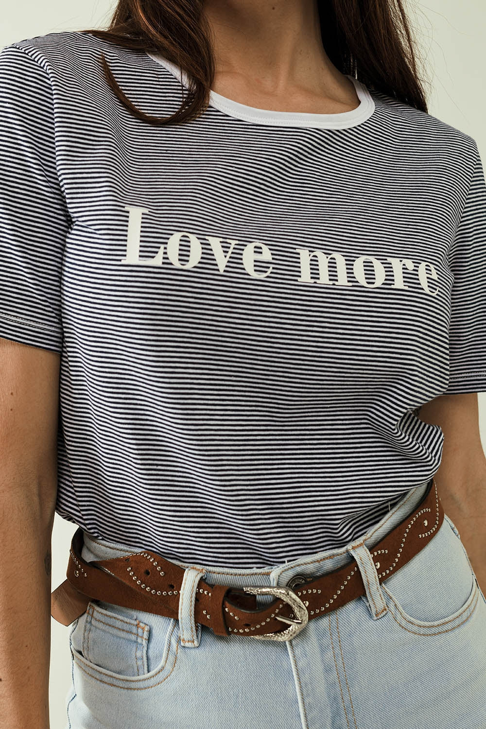 Camiseta blanca con rayas negras y texto Love More Q2