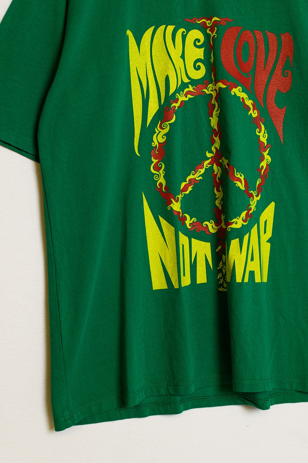 camiseta verde de manga corta con el logotipo Make love not war Q2