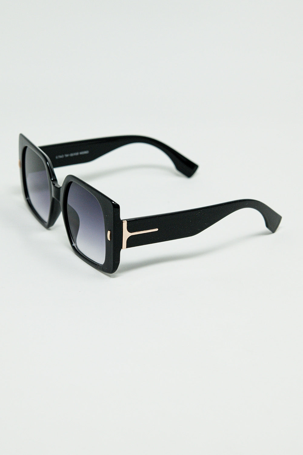 Gafas de sol cuadradas negras con detalle dorado en el lateral Q2