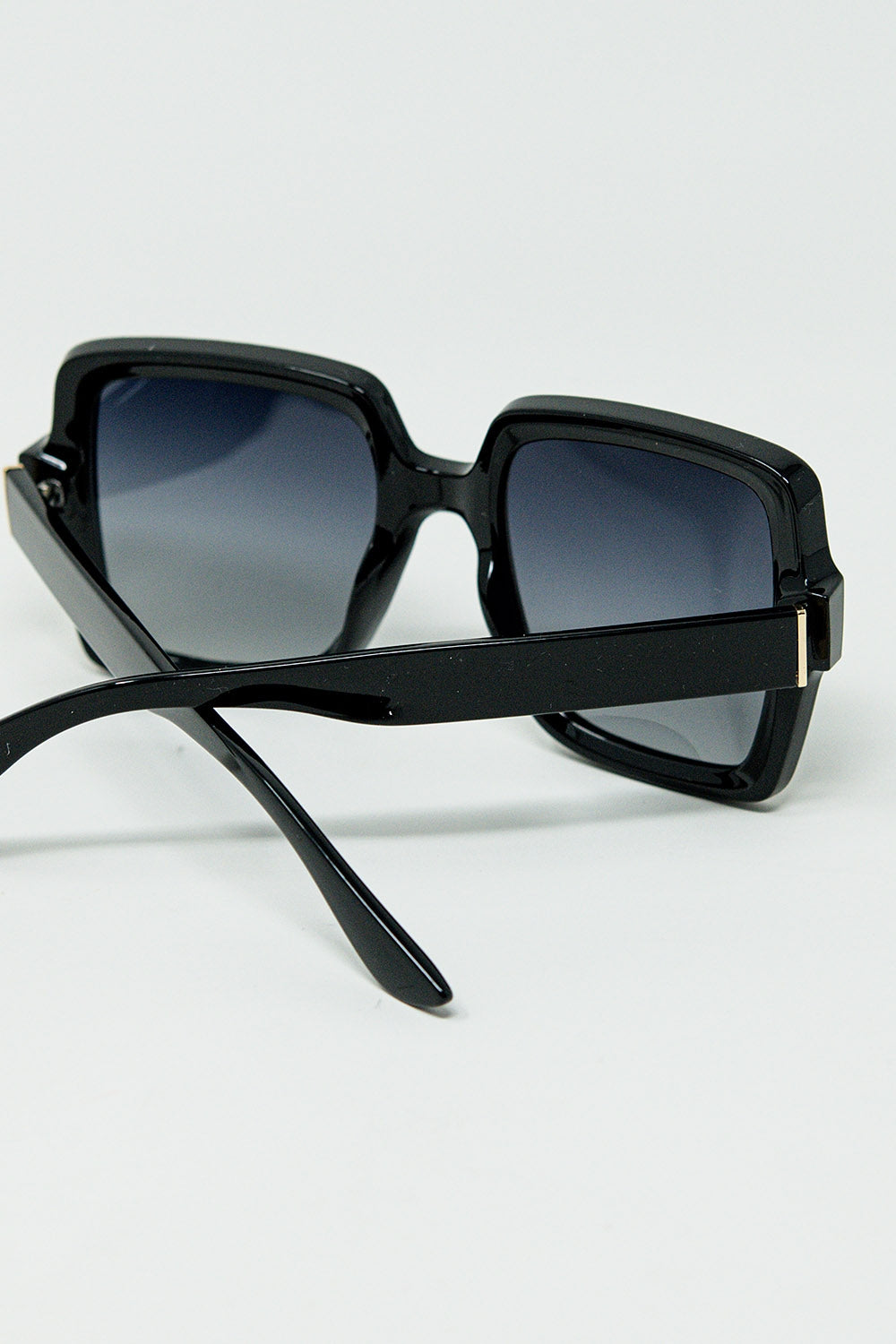 Gafas de sol de montura cuadrada ancha con detalle dorado en las patillas. Q2