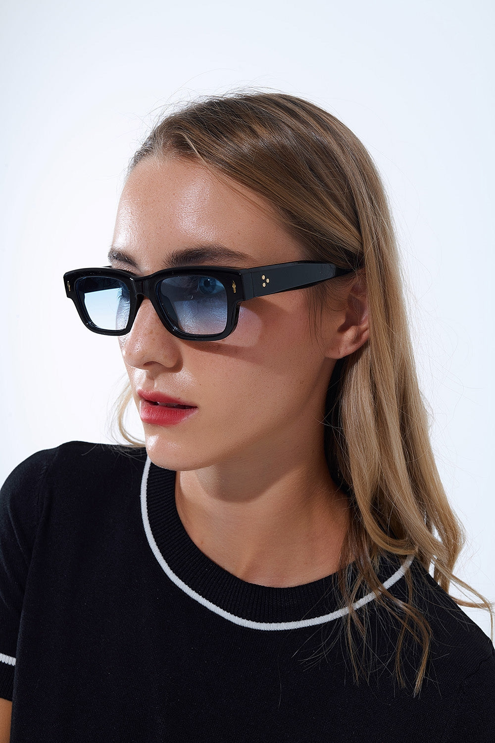Gafas de sol negras con montura ovalada con detalle dorado y cristal azul Q2