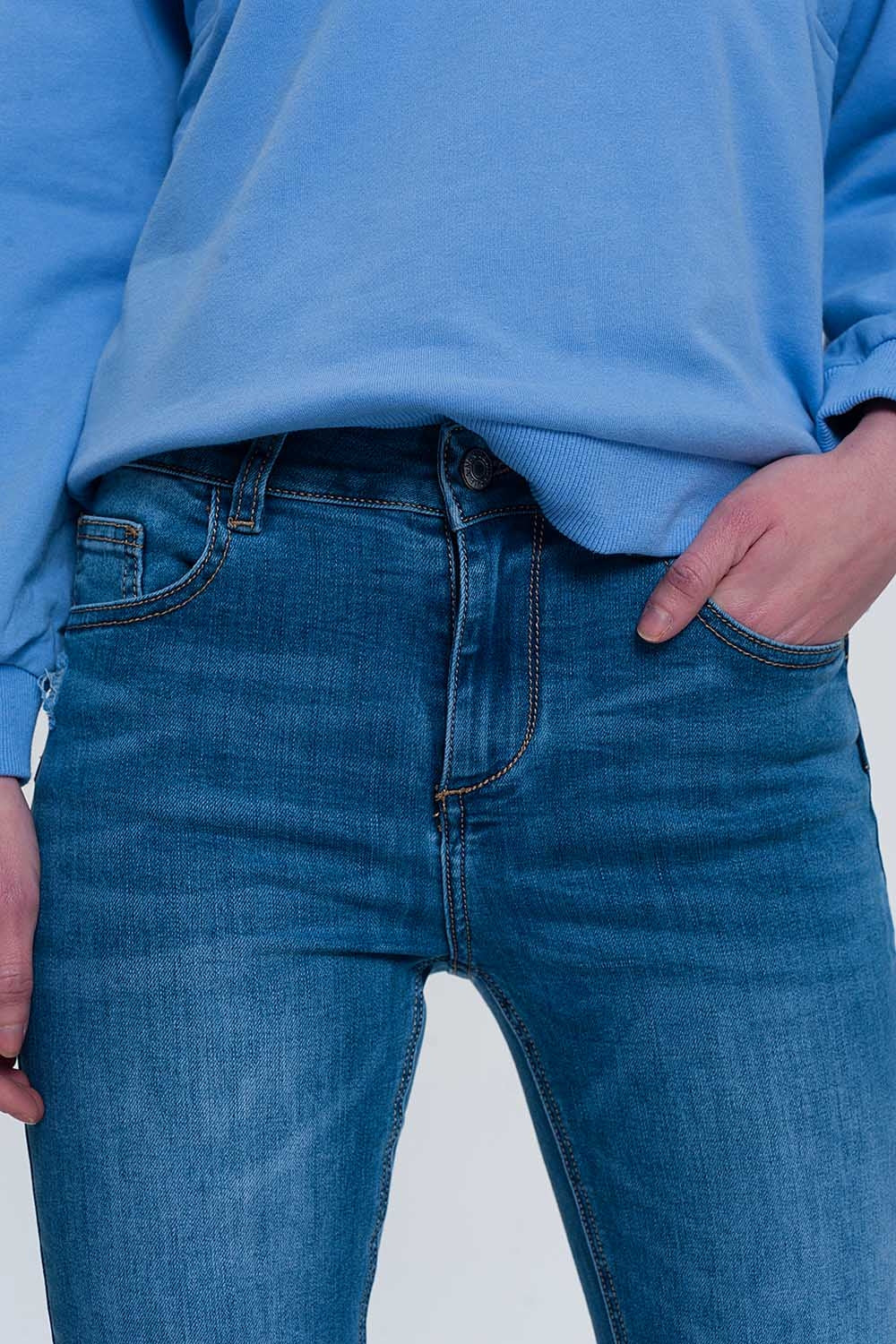 jeans ajustados de mezclilla clara con tobillos doblados y detalle rasgado Q2