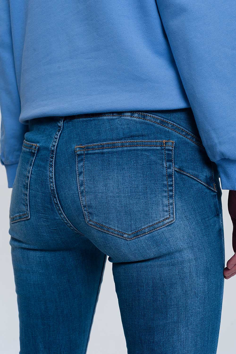 jeans ajustados de mezclilla clara con tobillos doblados y detalle rasgado Q2