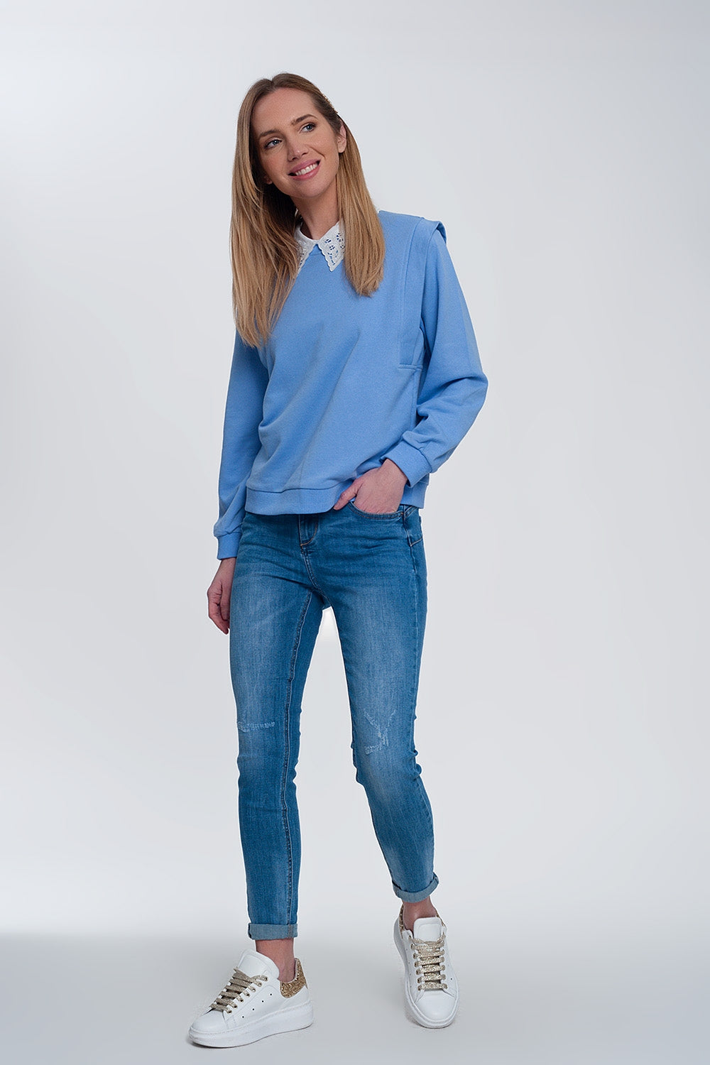 jeans ajustados de mezclilla clara con tobillos doblados y detalle rasgado Q2