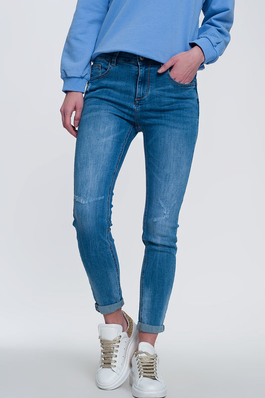 Q2 jeans ajustados de mezclilla clara con tobillos doblados y detalle rasgado