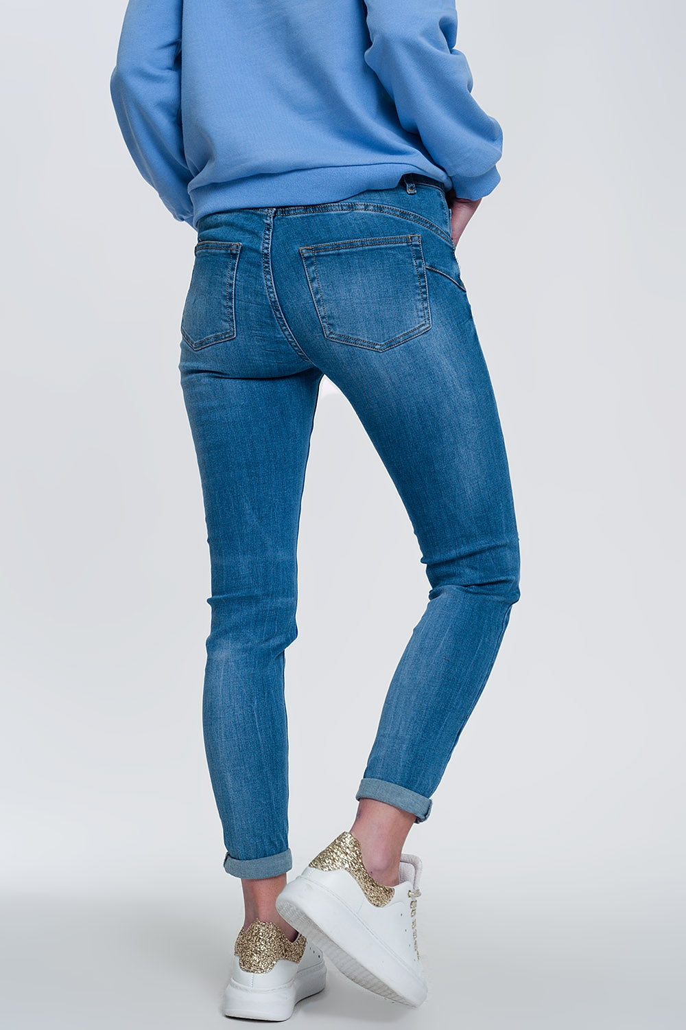 jeans ajustados de mezclilla clara con tobillos doblados y detalle rasgado Q2