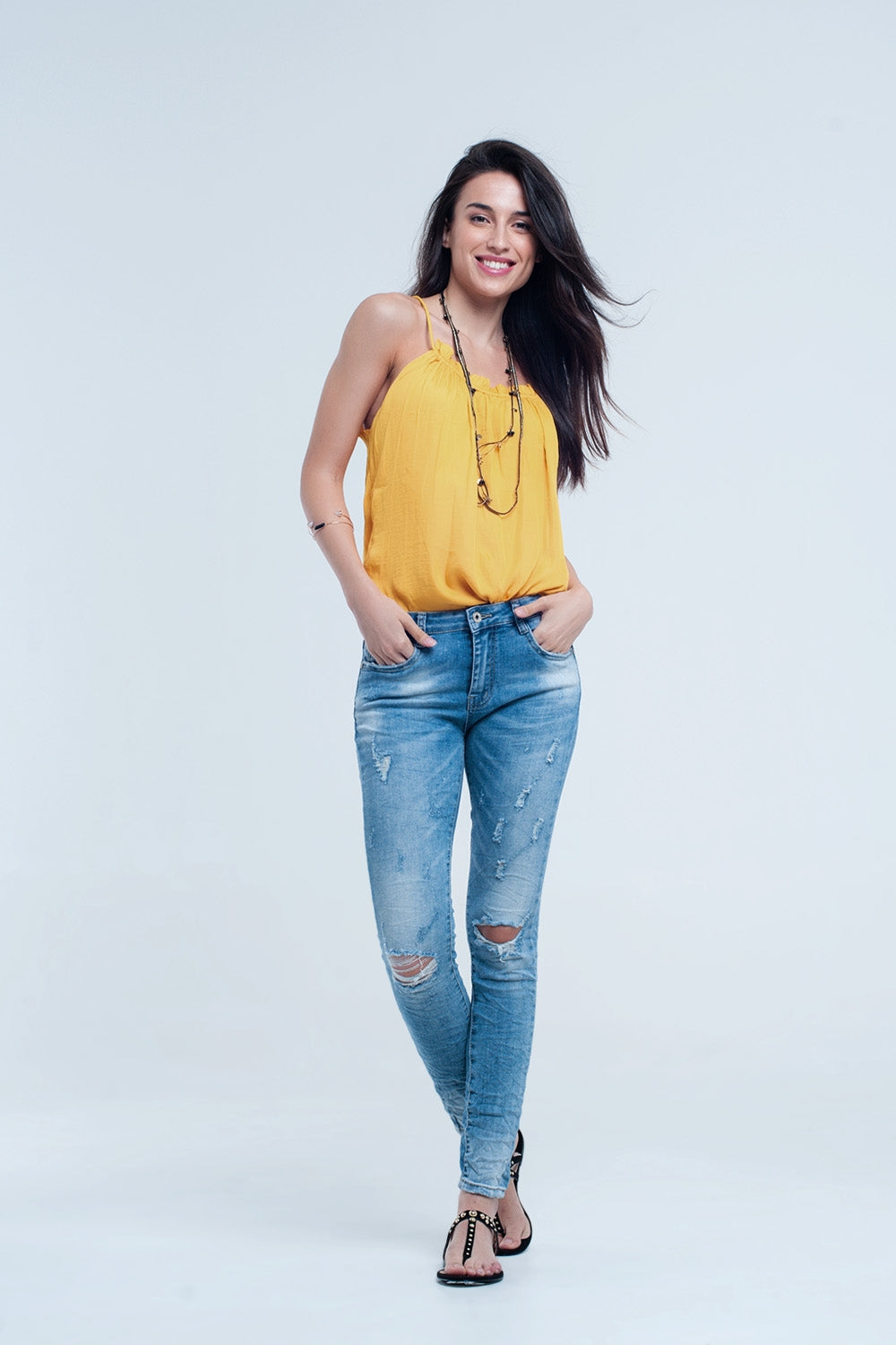Jeans pitillo en lavado medio con rotos en las rodillas Q2