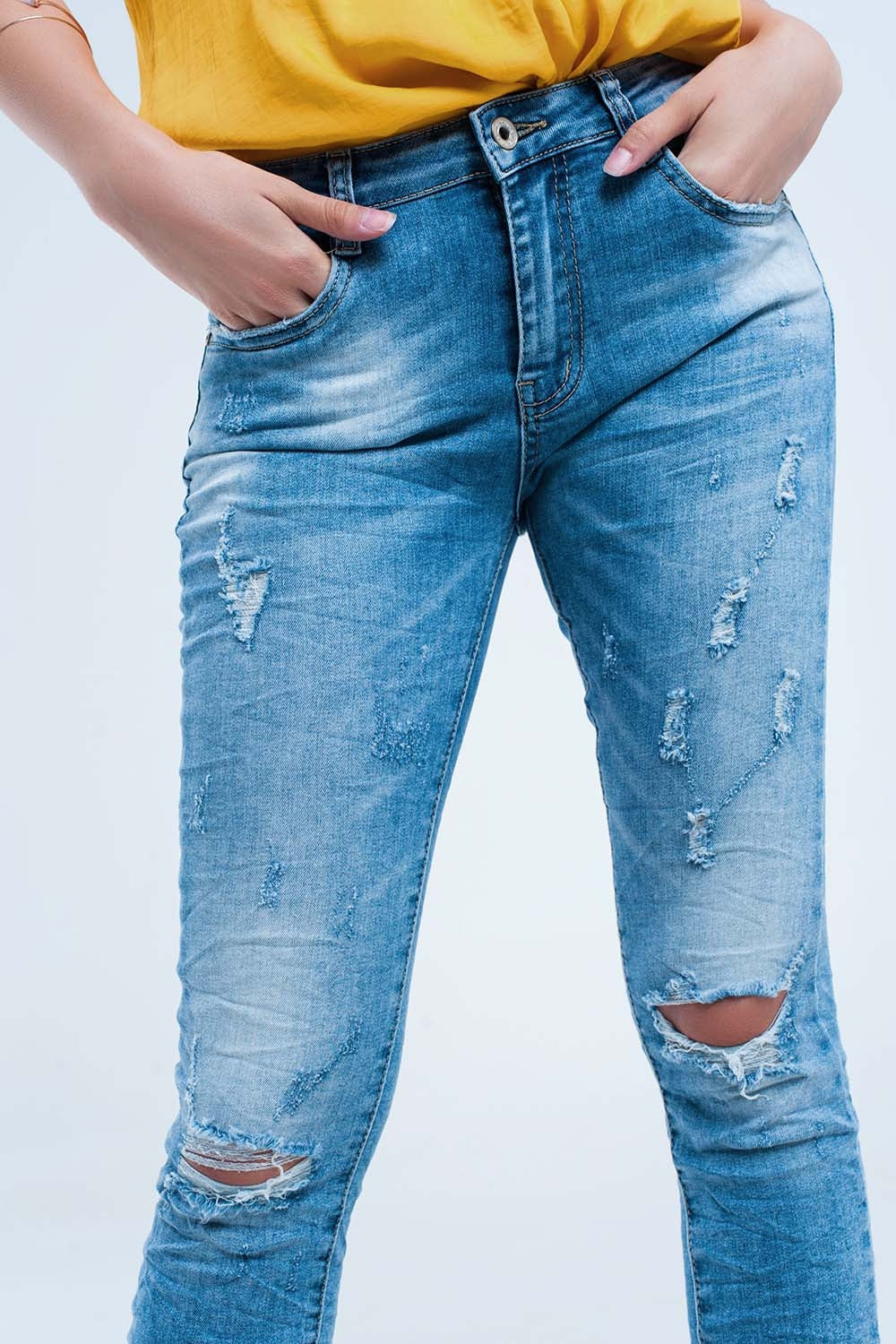 Jeans pitillo en lavado medio con rotos en las rodillas Q2
