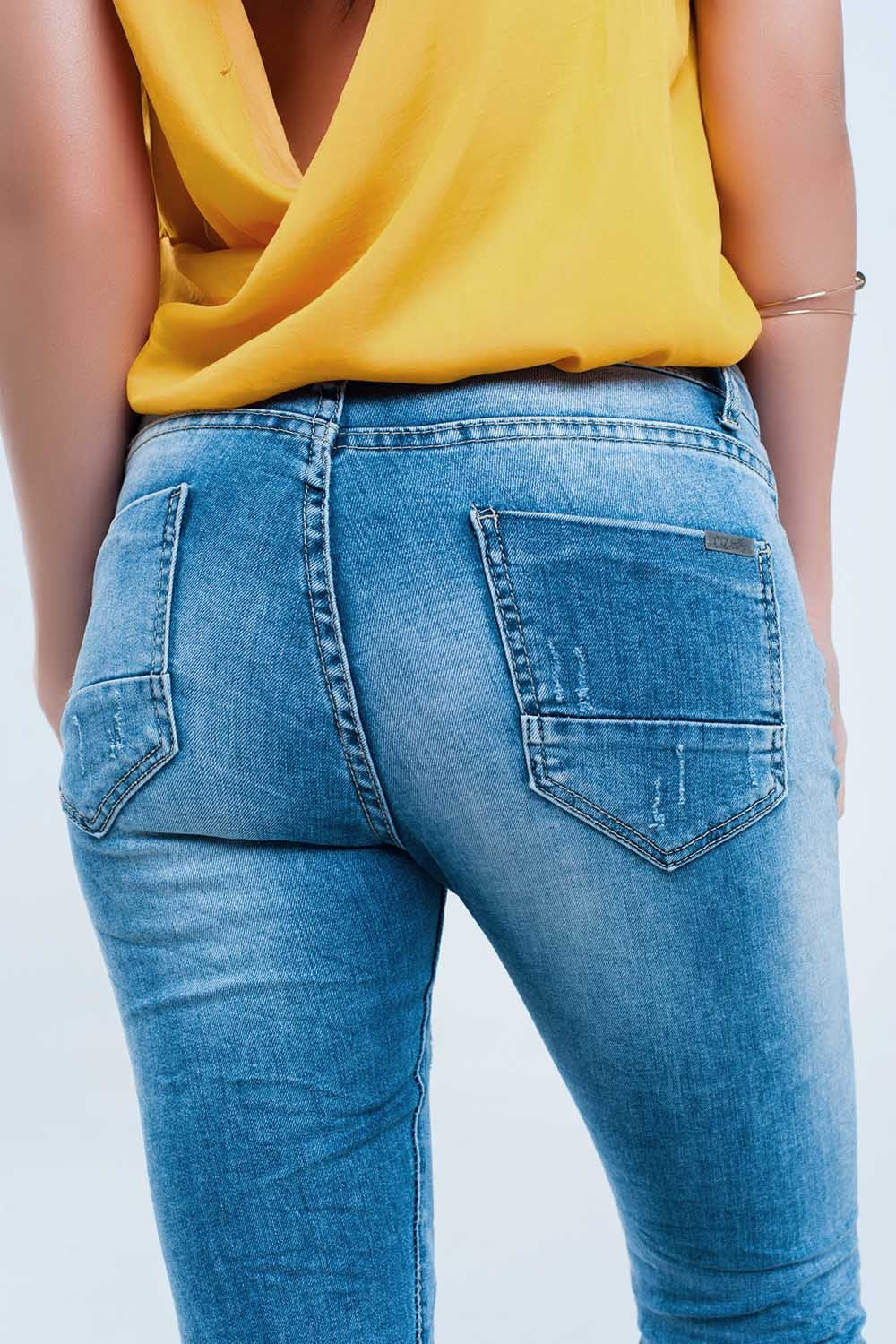 Jeans pitillo en lavado medio con rotos en las rodillas Q2