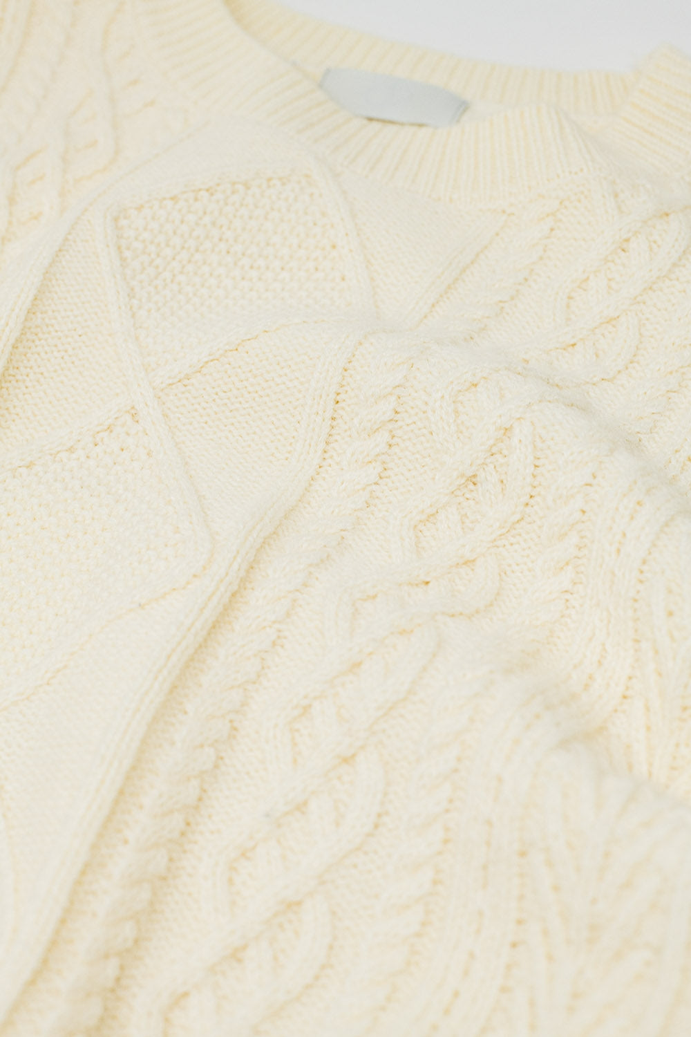 Jersey de punto suave color crema con diseño de cables Q2