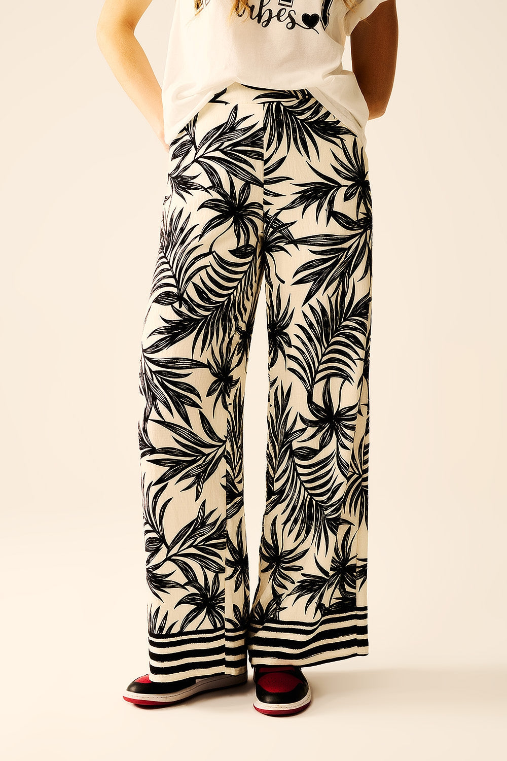 Pantalones de pierna ancha en blanco con detalle floral en negro Q2