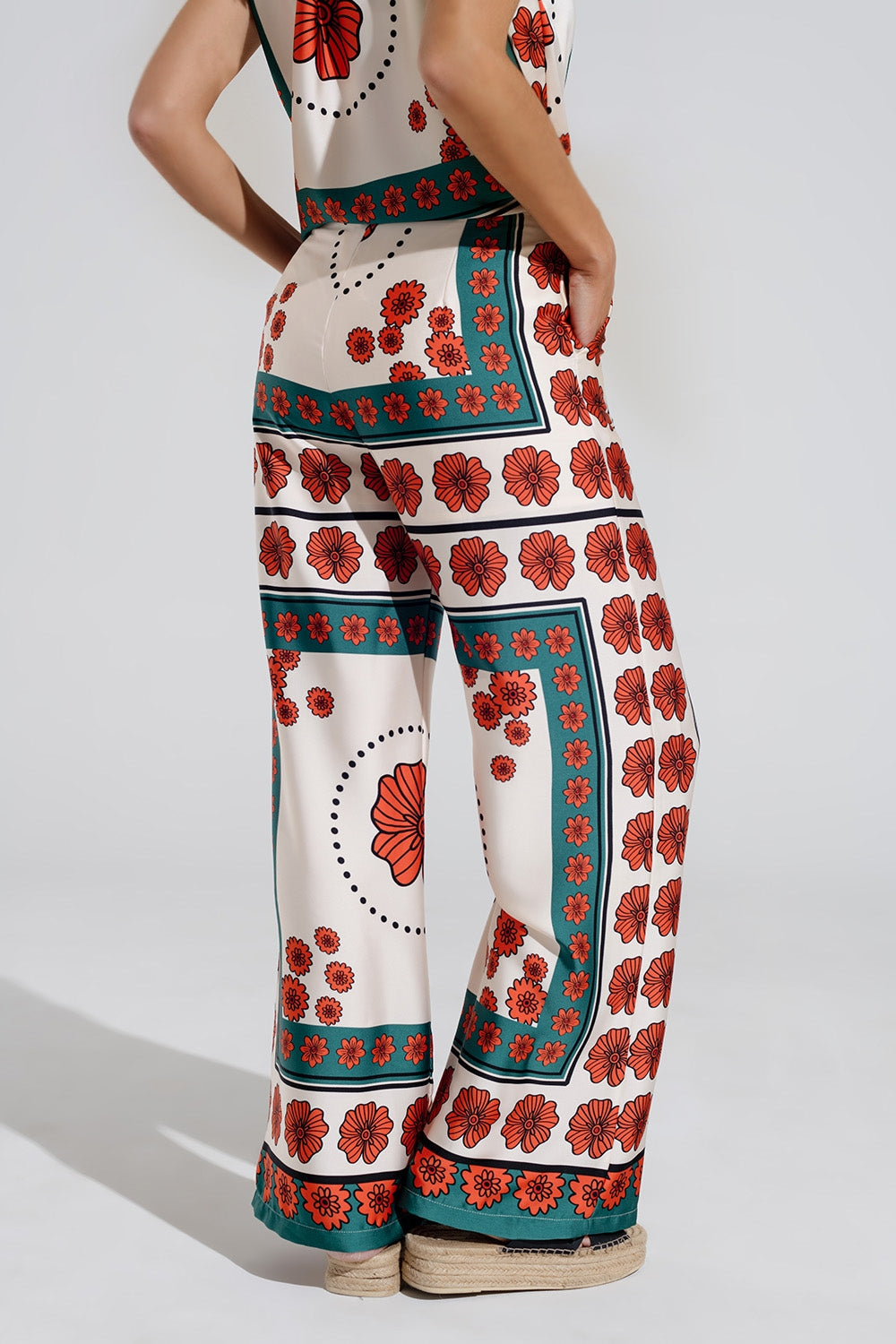 Pantalones de raso acampanados crema con diseño floral Q2