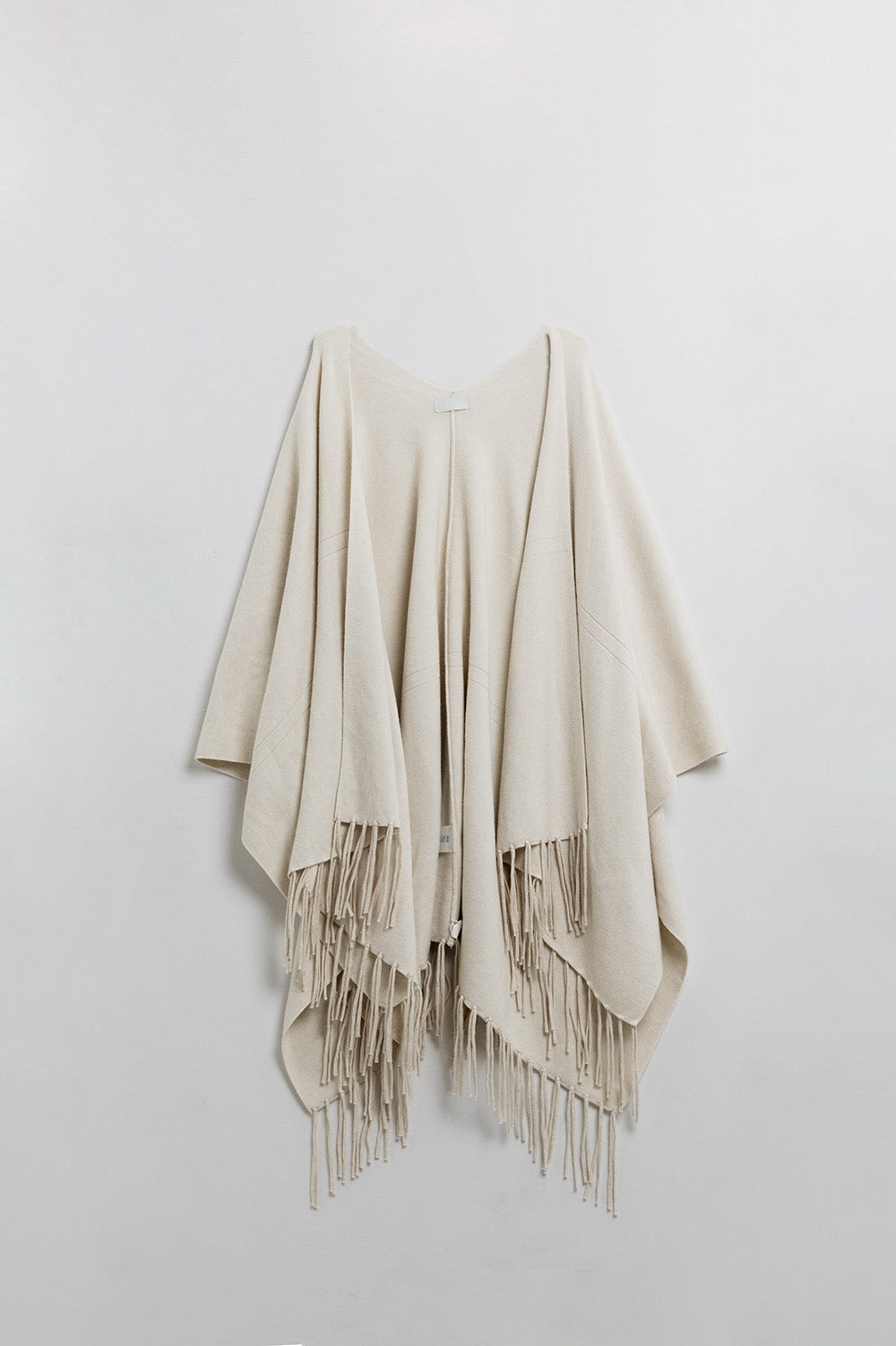 Suave poncho de punto beige con flecos Q2