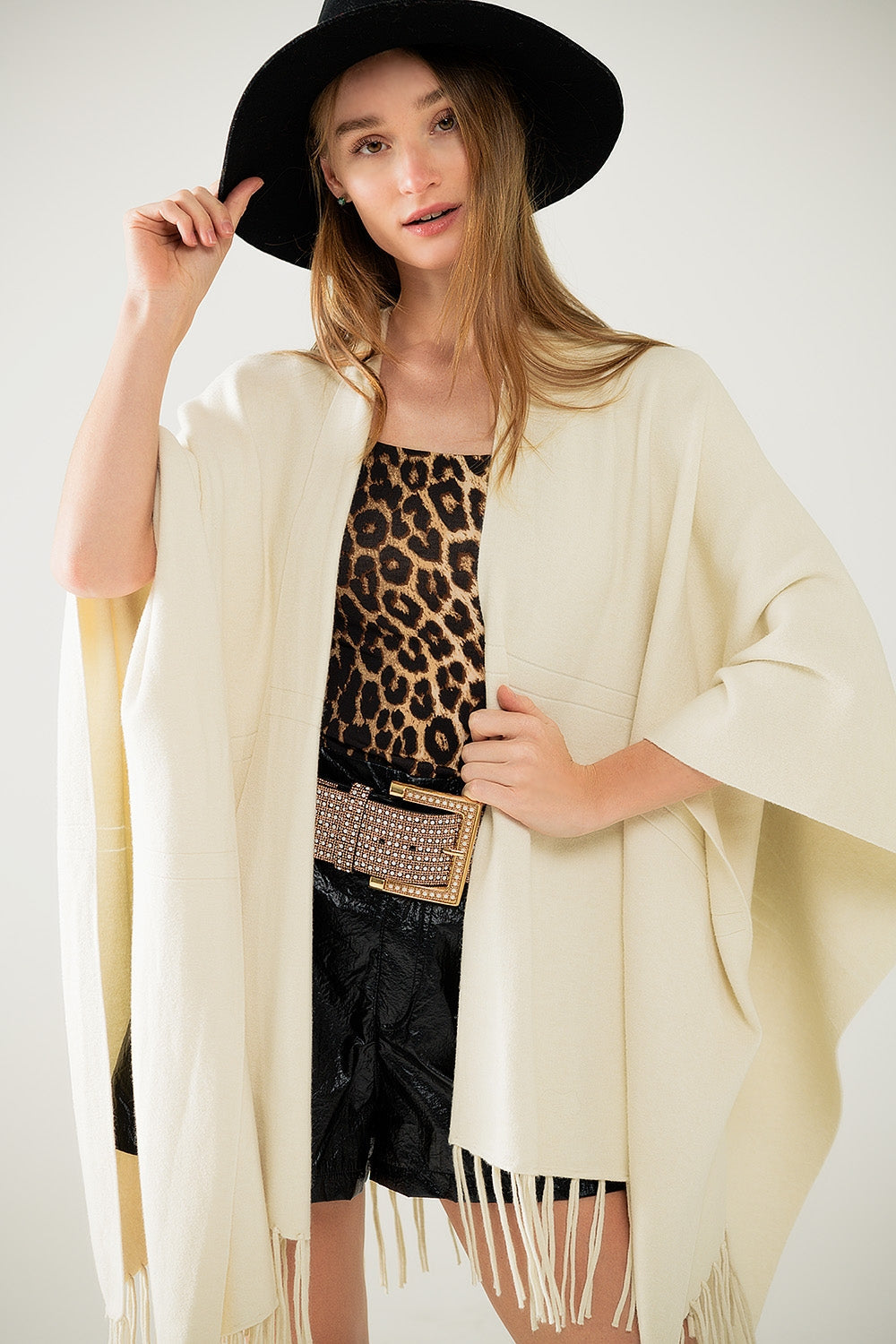 Suave poncho de punto beige con flecos Q2
