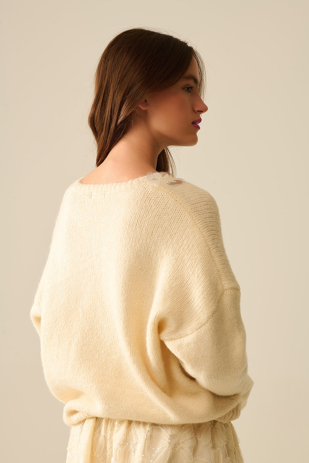 Suéter crema con cuello en V y detalle de lentejuelas Q2