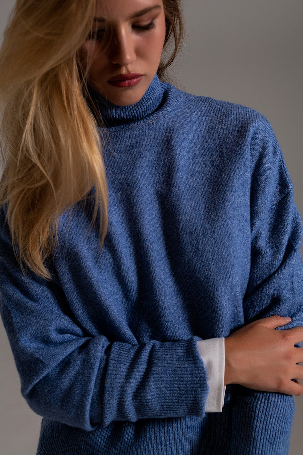 Suéter de cuello alto azul en una tela de punto suave Q2