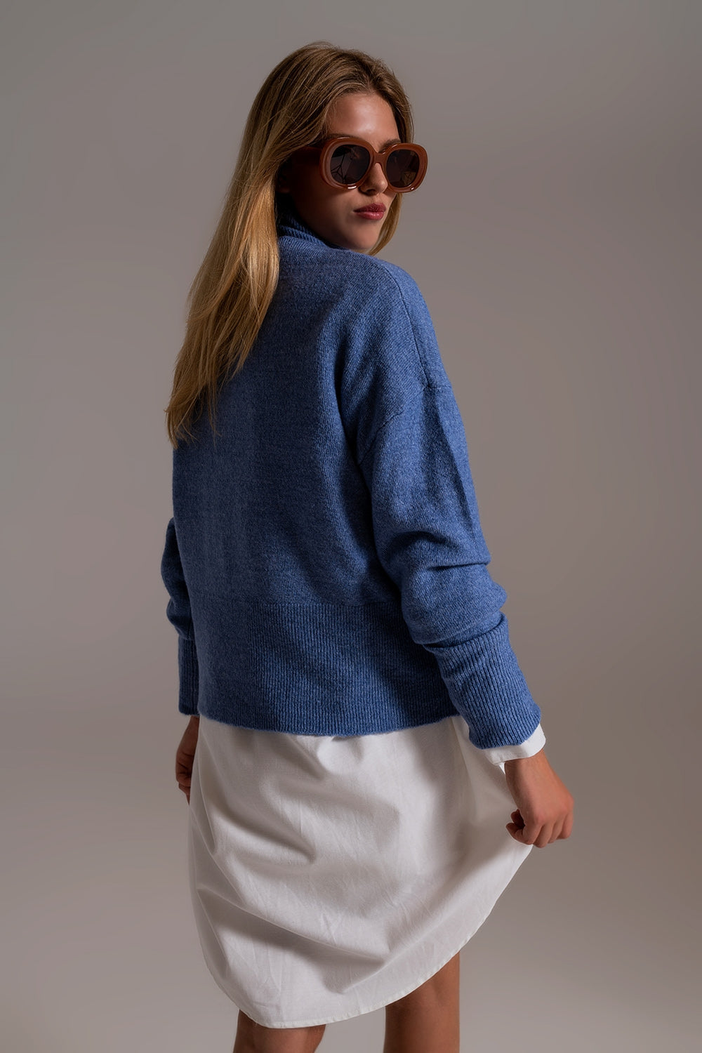 Suéter de cuello alto azul en una tela de punto suave Q2
