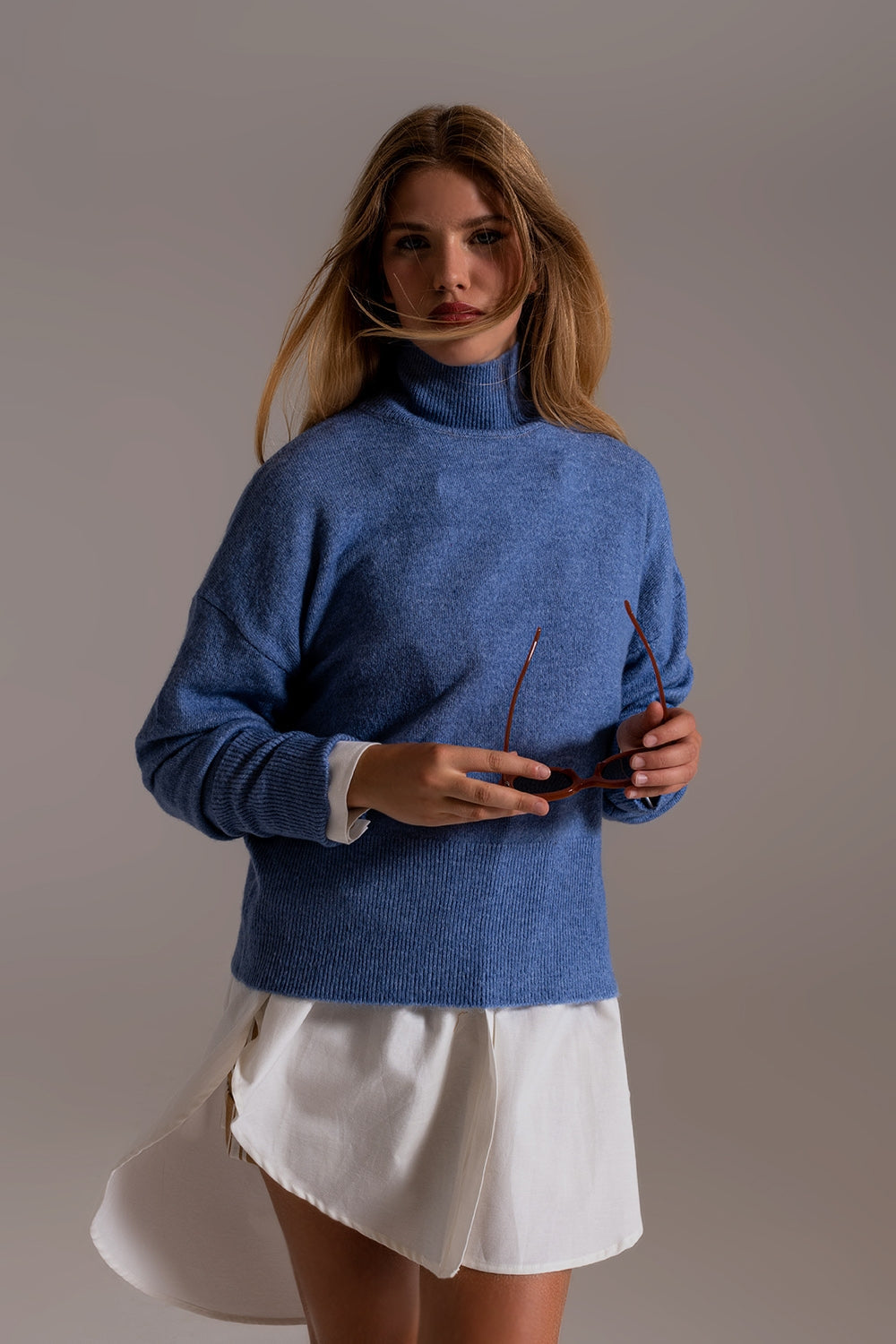 Suéter de cuello alto azul en una tela de punto suave Q2