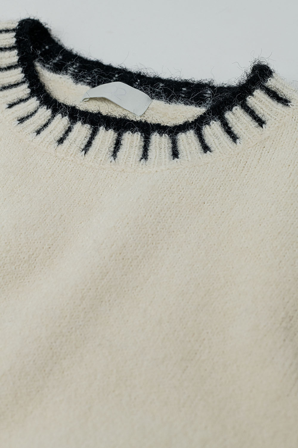 Suéter esponjoso de color crema con detalles de canalé en el cuello y el bajo Q2