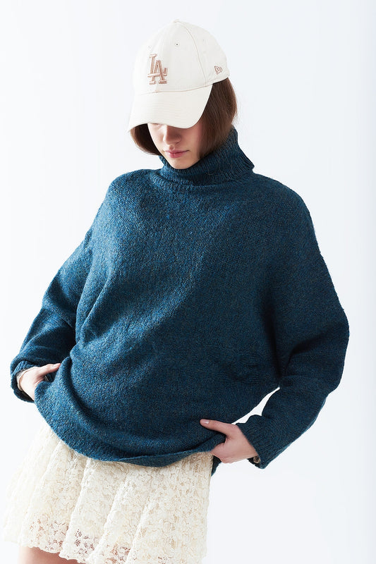 Q2 Suéter oversize en color verde azulado con cuello alto y mangas sueltas.