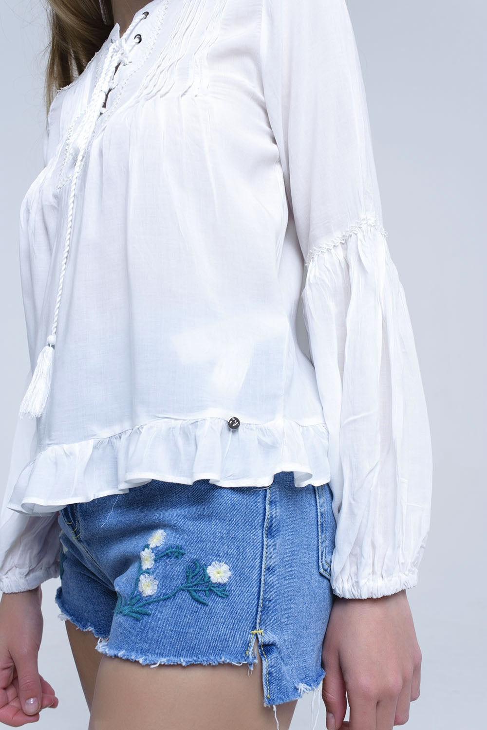 Top blanco con detalle anudado y bajo con volante Q2
