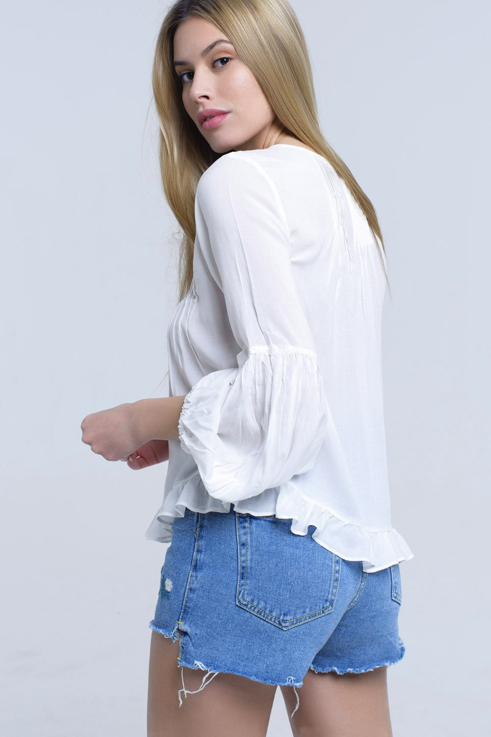 Top blanco con detalle anudado y bajo con volante Q2