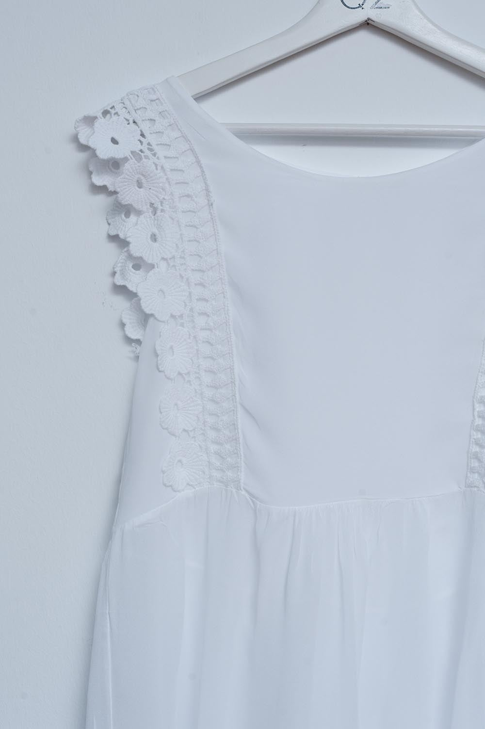 Top blanco con diseño bordado y detalle de volantes Q2