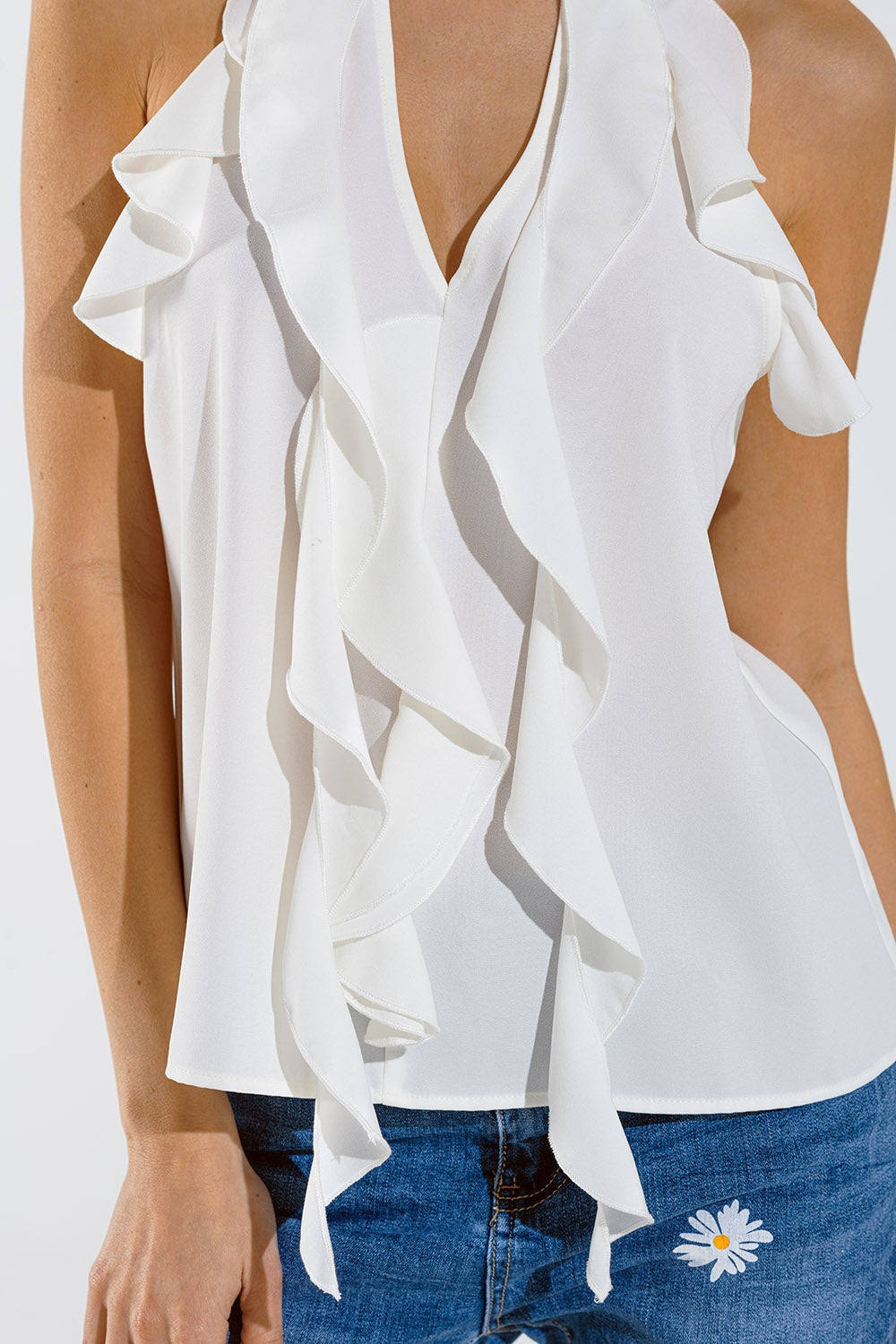 Top blanco sin mangas con detalles de volantes y cuello alto Q2