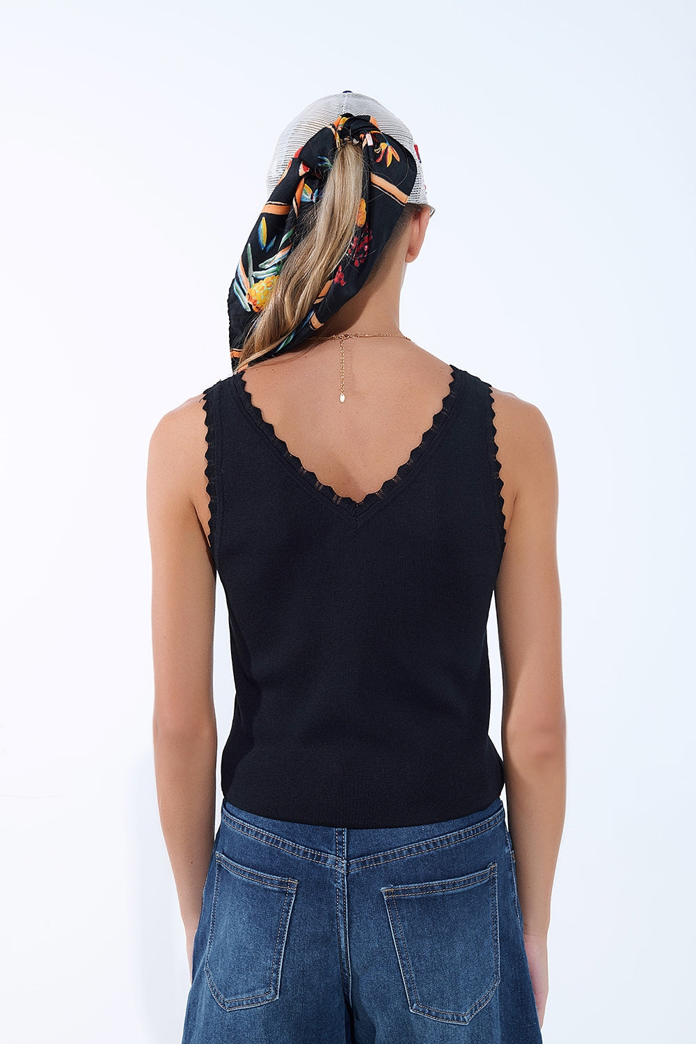 Top negro de punto con cuello en V y bordes festoneados Q2