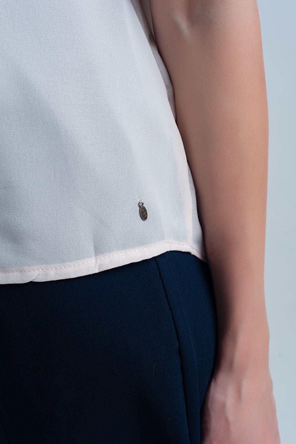 Top sin mangas beige con detalles de encaje Q2