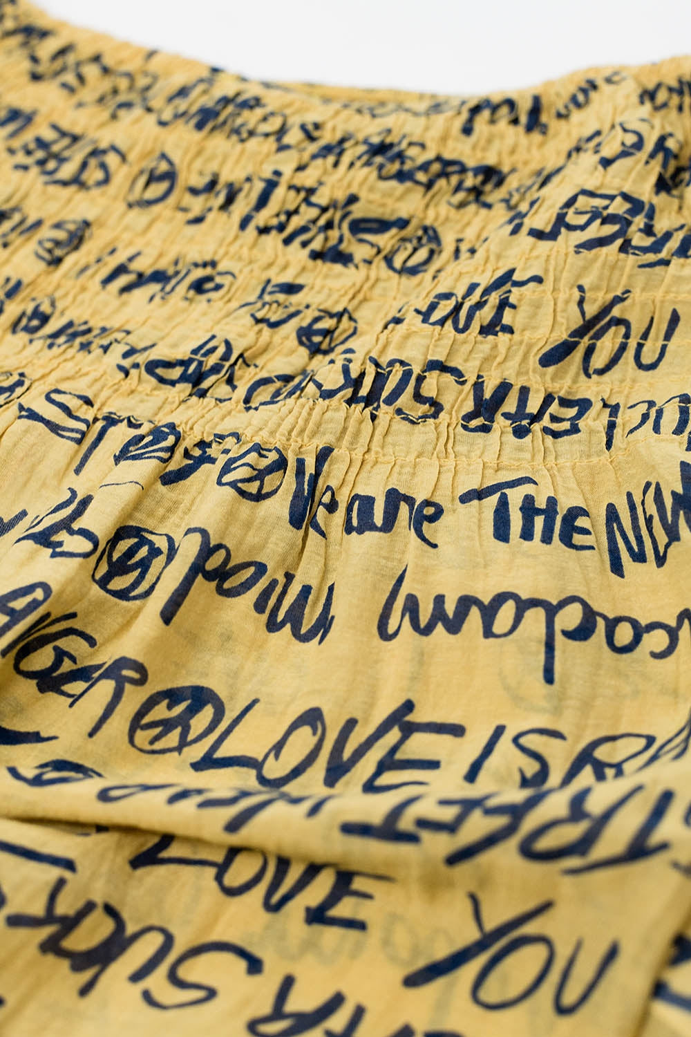 Top sin tirantes elástico amarillo con letras negras Q2
